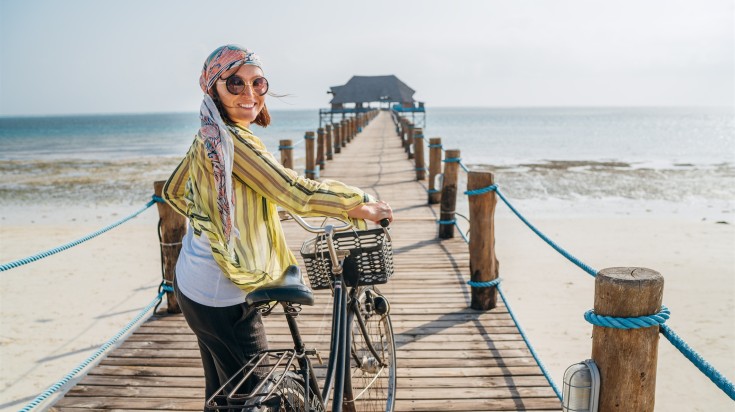 A woman cycling in Zanzibar Beach